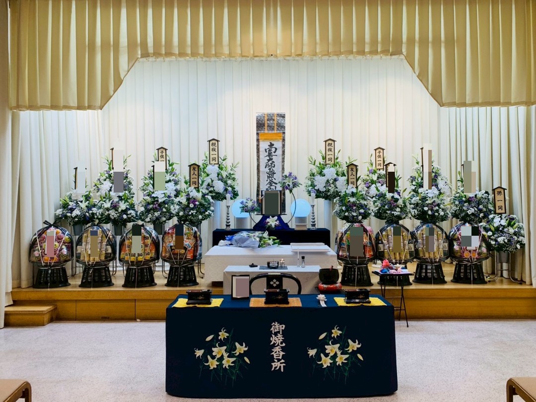 堺市で執り行われた前田家様の1日葬にて、白と紫を基調に供花や供物が多く並んだ花祭壇の様子